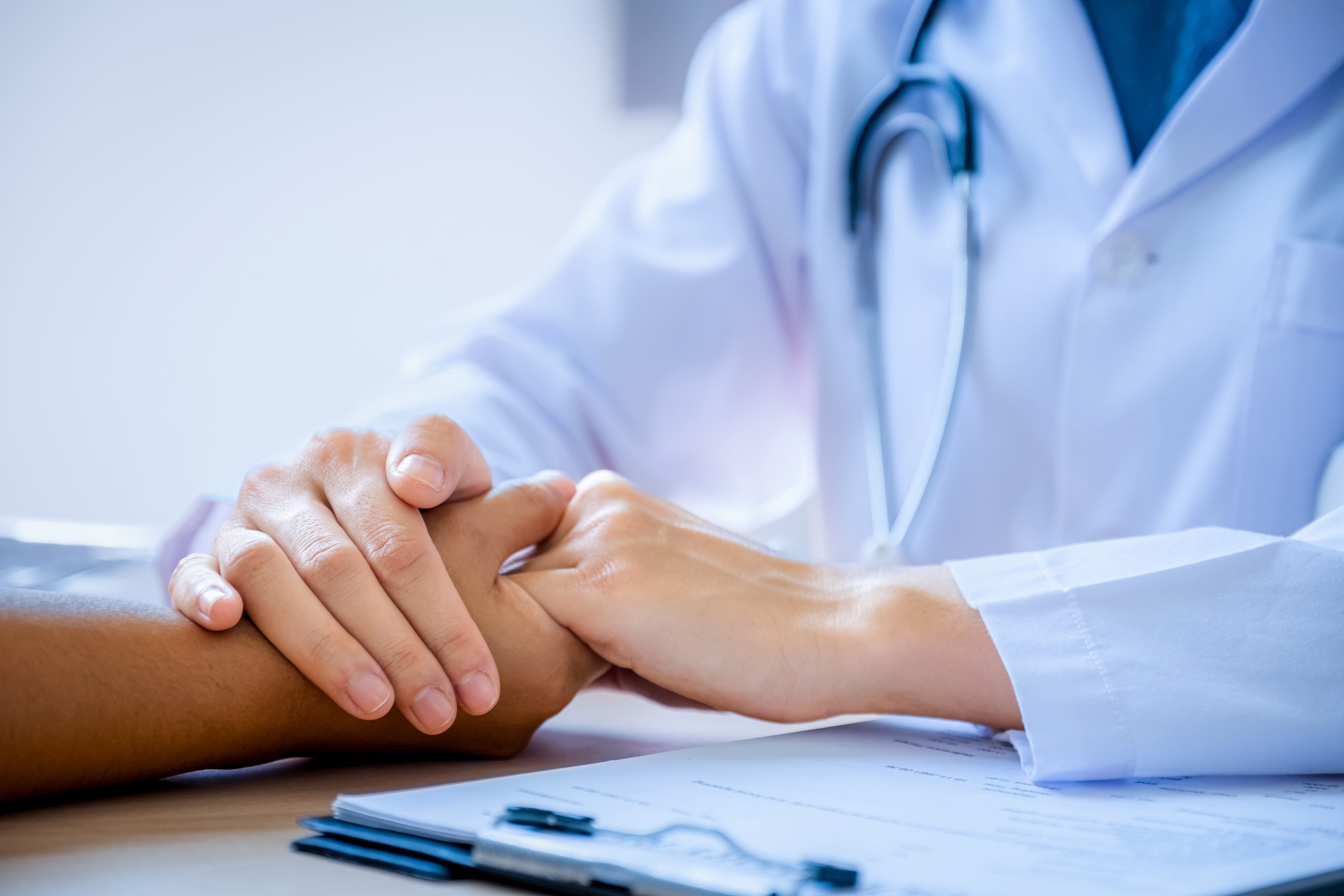 The doctor hands holding patient hand to encouragement and explained the health examination results, medical checkup concept.